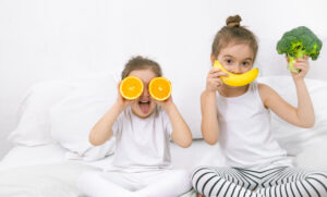 niños con verduras promoviendo la alimentación saludable