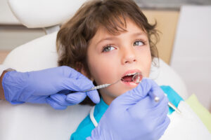 niño visita dentista para cuidar salud dental en la vuelta al cole